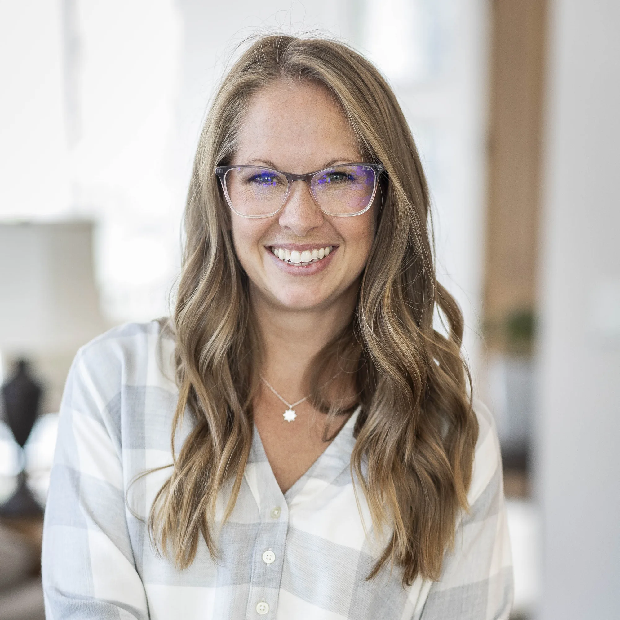 Christy Lowry smiling at camera wearing glasses and plaid shirt