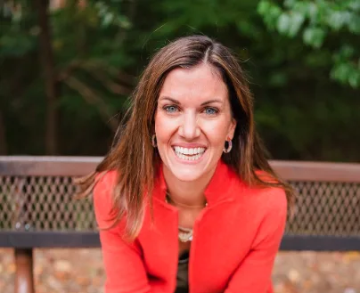 Megan Spivey smiling in orange blazer outdoors