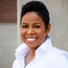 Smiling woman in white collared shirt, professional headshot portrait