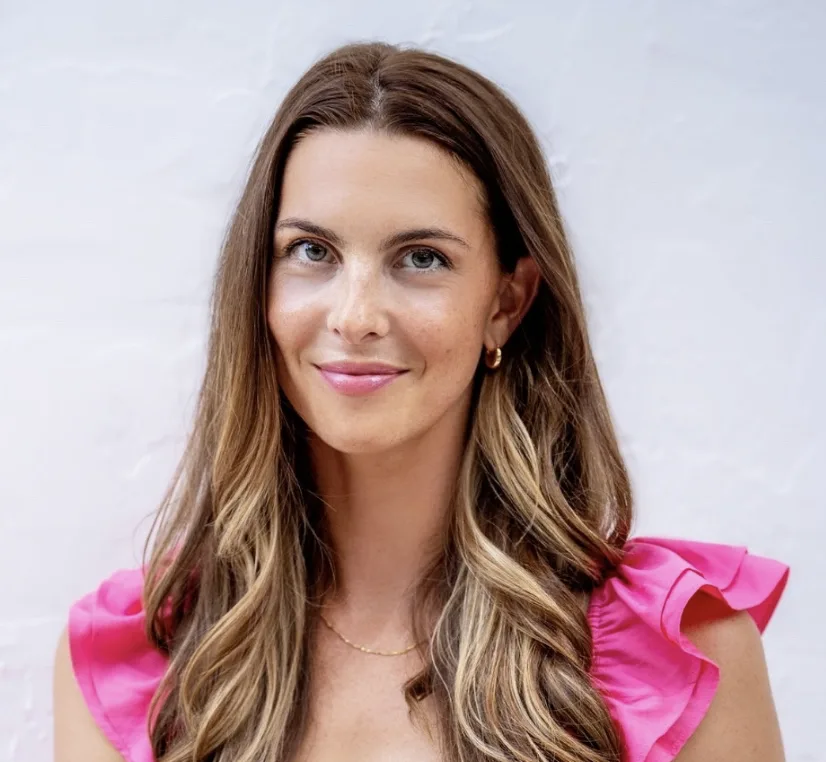 Woman with long brown hair wearing bright pink ruffled top