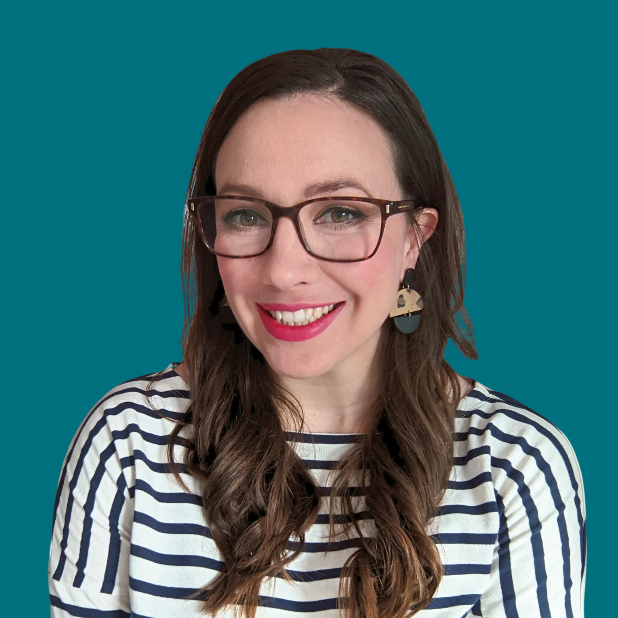Woman with glasses and striped shirt smiling against teal background