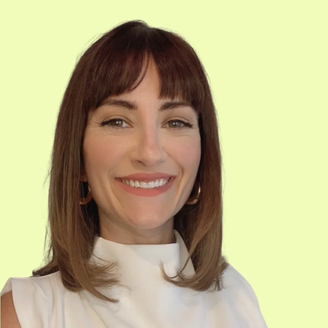 Shelly Kemmerer smiling in white top against pale yellow background